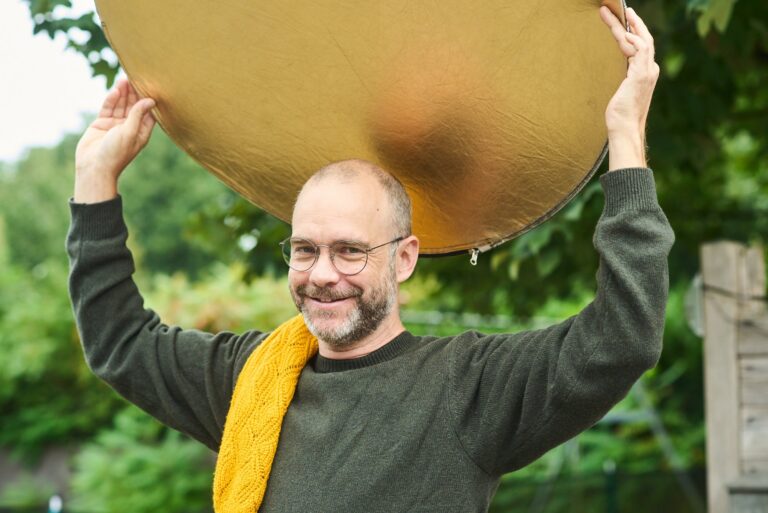 Sven Trogus hält einen Fotoreflektor über den Kopf