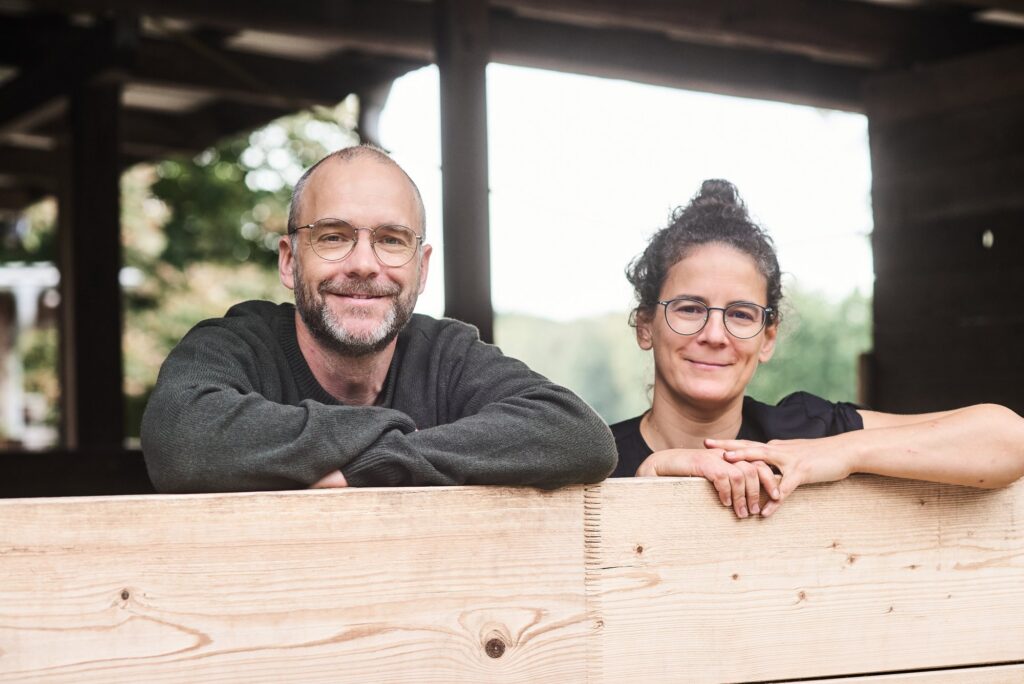 Barbara Roß und Sven Trogus lehnen an einer Holzbrüstung